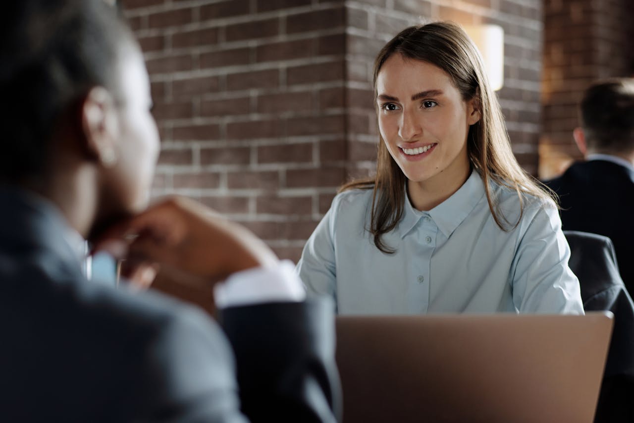 A professional business meeting with smiling individuals engaged in discussion.